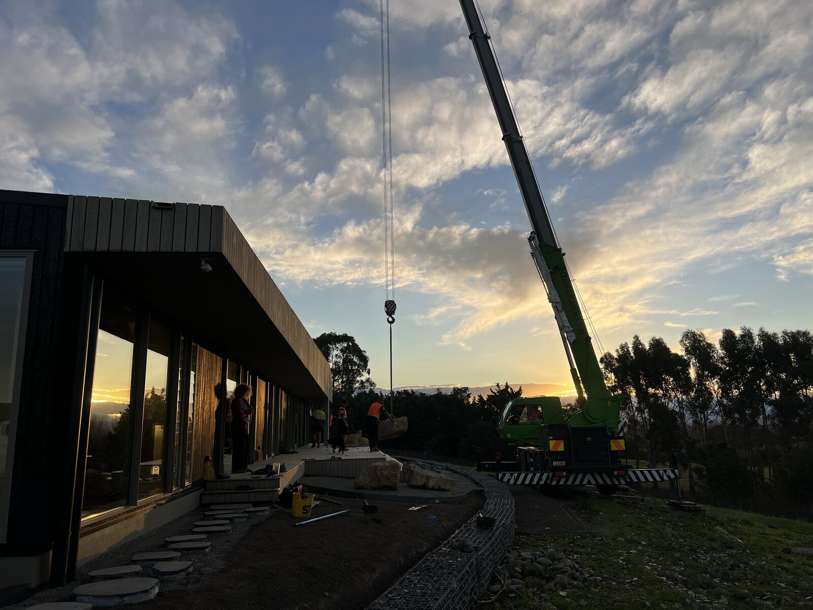 Craning a two-tonne boulder into place at sunset
