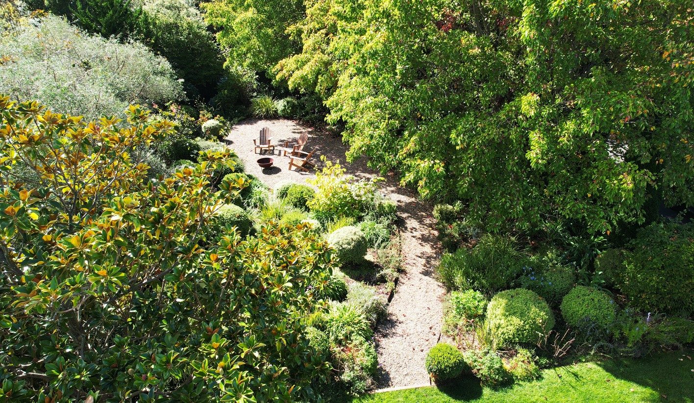 A Tim Durrant garden from above: gravel path curving to a fire bowl and chairs